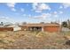 View of a spacious backyard showing the home's exterior, including a brick wall and covered patio at 7412 W 76Th Ave, Arvada, CO 80003