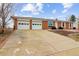 A single story brick home with a two car garage and a driveway at 7412 W 76Th Ave, Arvada, CO 80003