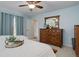Charming bedroom featuring a ceiling fan, dresser, and a decorative tray on the cozy white bed at 9172 W 88Th Cir, Westminster, CO 80021