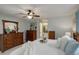 Bright main bedroom boasts wood furniture, ceiling fan, ensuite bath access and neutral paint at 9172 W 88Th Cir, Westminster, CO 80021