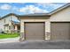 Detached garages with neutral colored doors and stone accents with unit letters on the doors at 1415 S Chambers #106 Rd, Aurora, CO 80017