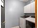 Functional laundry room with modern washer and dryer, storage cabinets, and neutral walls at 1415 S Chambers #106 Rd, Aurora, CO 80017