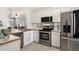 Modern kitchen features stainless steel appliances, white cabinets, and ample counter space for food preparation at 1885 S Quebec Way # G104, Denver, CO 80231