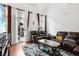 Comfortable living room with plush leather sofas, stylish rug, and bright natural light from a private balcony at 1885 S Quebec Way # G104, Denver, CO 80231