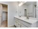Bathroom with a double vanity and modern fixtures with an adjacent door to closet at 16794 W 94Th Way, Arvada, CO 80007