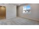 A carpeted bedroom featuring an open door and a well-lit window at 16794 W 94Th Way, Arvada, CO 80007