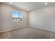 An airy carpeted bedroom with a large window at 16794 W 94Th Way, Arvada, CO 80007