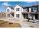 Modern townhome featuring a white and gray facade, large windows, and a welcoming entryway with a landscaped front at 16794 W 94Th Way, Arvada, CO 80007