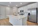 Bright kitchen with white cabinets, stainless appliances, kitchen island and hardwood floors at 16794 W 94Th Way, Arvada, CO 80007