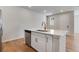 Bright kitchen island featuring a stainless steel dishwasher, brass faucet, and white cabinets at 16794 W 94Th Way, Arvada, CO 80007