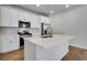 Bright kitchen with white cabinets, stainless appliances, kitchen island, quartz countertops and hardwood floors at 16794 W 94Th Way, Arvada, CO 80007