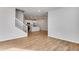 Open-concept living area with hardwood floors, white walls, staircase, and bright kitchen view at 16794 W 94Th Way, Arvada, CO 80007