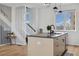 Bright kitchen island with seating, modern fixtures, hardwood floors, and stairs in the background at 3101 W 47Th Ave # 14, Denver, CO 80211