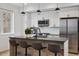 Modern kitchen island with barstool seating, pendant lighting, stainless steel appliances, and minimalist design at 3101 W 47Th Ave # 14, Denver, CO 80211