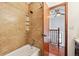 Bathroom featuring a bathtub, tiled walls, and a glimpse into an adjacent room at 9125 Lowell Ct, Westminster, CO 80031
