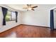 Bright bedroom featuring hardwood floors, a ceiling fan, and a large window with curtains at 9125 Lowell Ct, Westminster, CO 80031