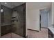 Modern bathroom with walk in shower, tile surround, and access to the laundry area at 1750 Wewatta St # 1102, Denver, CO 80202