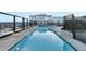 Rooftop pool with stunning city views, lounge chairs, and clear glass railing at 1750 Wewatta St # 1102, Denver, CO 80202