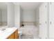 Bathroom featuring a soaking tub, neutral tile surround, white vanity, and tile flooring at 4222 S Blackhawk Cir # 6C, Aurora, CO 80014