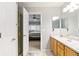 Bright bathroom with white cabinetry, shower, and vanity and bedroom beyond open doorway at 4222 S Blackhawk Cir # 6C, Aurora, CO 80014