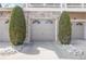 Attached single car garage with an arched window and a concrete driveway enhanced by two large shrubs at 4222 S Blackhawk Cir # 6C, Aurora, CO 80014