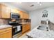 Well-lit kitchen with stainless steel appliances, granite countertops and wooden cabinets at 4222 S Blackhawk Cir # 6C, Aurora, CO 80014