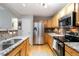 Modern kitchen with stainless steel appliances, granite countertops, and natural wood cabinets at 4222 S Blackhawk Cir # 6C, Aurora, CO 80014