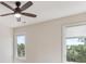 Bright bedroom with a ceiling fan, neutral paint, and two windows showcasing the outdoor landscape at 902 Anaconda Ct, Castle Rock, CO 80108