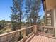Open deck with metal and wood railing boasting a view of mature evergreen trees at 902 Anaconda Ct, Castle Rock, CO 80108