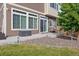The back patio has a sliding glass door, seating, well-manicured landscaping, and grassy yard at 242 S Old Hammer Ct, Aurora, CO 80018