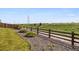 The backyard has lush green grass, wooden fence, rock border, and beautiful landscaping at 242 S Old Hammer Ct, Aurora, CO 80018
