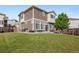 The back of the home features a grassy yard and patio seating area at 242 S Old Hammer Ct, Aurora, CO 80018