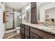 Bathroom features granite counters, double sinks, wood cabinets, and a glass shower at 242 S Old Hammer Ct, Aurora, CO 80018