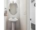 Half-bathroom features a pedestal sink, decorative mirror, and a towel rack at 242 S Old Hammer Ct, Aurora, CO 80018