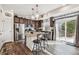 Spacious kitchen with granite counters, island seating, stainless appliances, and patio access at 242 S Old Hammer Ct, Aurora, CO 80018