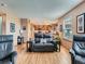 Cozy living room featuring a comfortable reclining couch, hardwood floors, and an open view into the kitchen at 3691 Bucknell Dr, Highlands Ranch, CO 80129