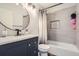Stylish bathroom features tile shower with niche, modern vanity, and round mirror at 4640 Fairplay Way, Denver, CO 80239