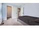 Cozy bedroom showcasing plush carpet, black bedspread, and access to two closets at 4640 Fairplay Way, Denver, CO 80239
