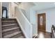 Inviting entryway featuring hardwood floors, staircase, and natural wood door with decorative glass at 4640 Fairplay Way, Denver, CO 80239