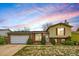 Charming home featuring a well-maintained lawn, brick accents, and a two-car garage at 4640 Fairplay Way, Denver, CO 80239