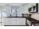 Stylish kitchen featuring modern appliances, white cabinetry, and granite countertops at 4640 Fairplay Way, Denver, CO 80239