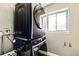 Bright laundry room featuring a stacked Samsung washer and dryer with a window view at 4640 Fairplay Way, Denver, CO 80239