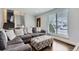 The spacious living room has an ottoman, hardwood floors, and lots of natural light through the window at 4640 Fairplay Way, Denver, CO 80239