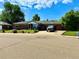 A brick home boasts a well-maintained lawn, mature trees, and a long driveway leading to an attached garage at 10425 Franklin Way, Northglenn, CO 80233