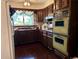 Retro kitchen showcasing dark wood cabinetry, vintage appliances, and unique design elements, offering a nostalgic charm at 10425 Franklin Way, Northglenn, CO 80233