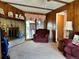 Cozy living room featuring brick fireplace, wood-paneled walls, and a sliding glass door to the backyard at 10425 Franklin Way, Northglenn, CO 80233