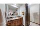 Well-lit bathroom with a large mirror, wooden cabinets, and a separate room for the toilet/shower at 7865 S Lafayette Ct, Centennial, CO 80122