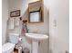 Cozy bathroom featuring modern fixtures, a pedestal sink, and a warm, inviting atmosphere at 7865 S Lafayette Ct, Centennial, CO 80122