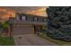 Charming two-story home with a two-car garage, basketball hoop, beautiful lawn, and mature tree at sunset at 7865 S Lafayette Ct, Centennial, CO 80122