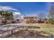 Spacious backyard featuring a two-story home with a deck, patio, stone pathway, and a manicured lawn at 18056 E Mansfield Ave, Aurora, CO 80013